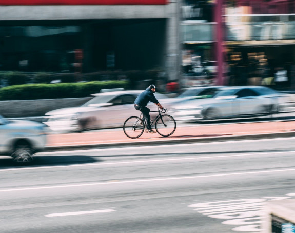 Foto: Radfahrer auf Radweg inmitten einer vierspurigen Fahrbahn 