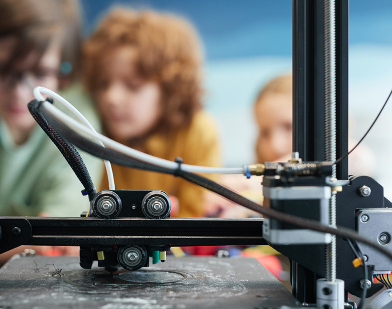 Kinder testen einen 3D-Drucker