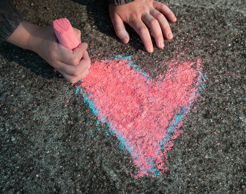Kind malt mit Kreide ein Herz