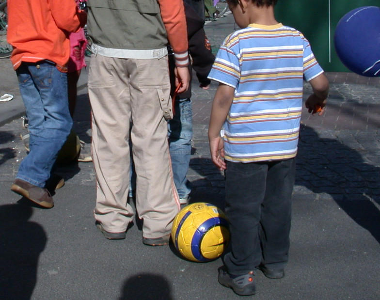 Foto eines Kindes, vor dem ein gelber Ball liegt.