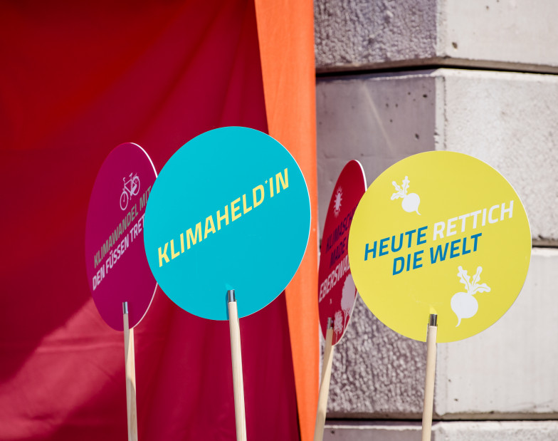 Foto: verschieden farbige Scheiben mit Slogans zum Klimaschutz