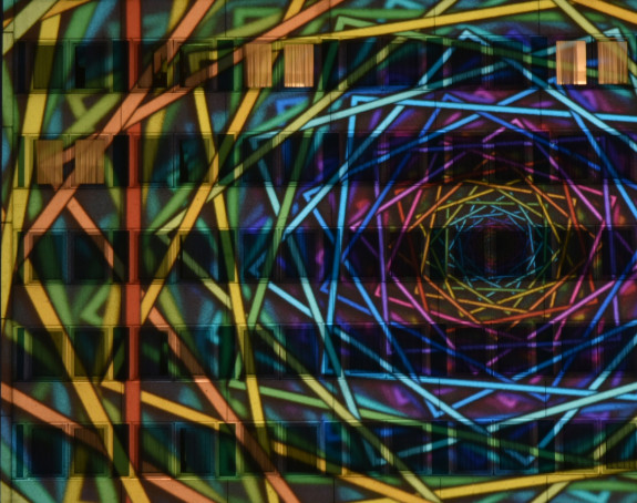 Foto: ein abstraktes Bild wurde per Lasershow auf ein hohes Gebäude projeziert.