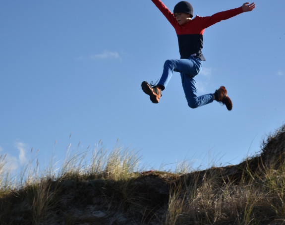 Foto eines hoch und weit springenden Jungen