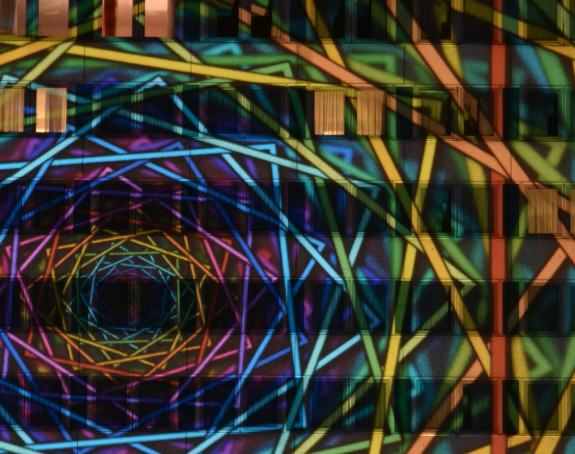 Foto: ein abstraktes Bild wurde per Lasershow auf ein hohes Gebäude projeziert.