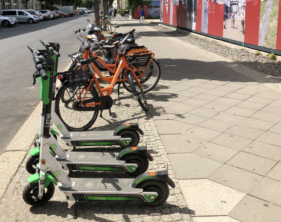 Foto: E-Scooter und Leihfahrräder abgestellt auf einem Gehweg