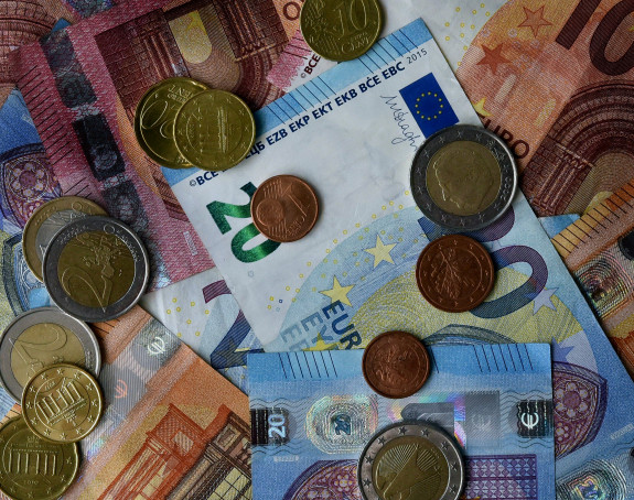 Foto von übereinanderliegenden Geldscheinen und Münzen (Euro)