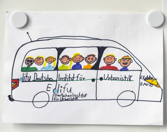 Foto eines Kinderbildes: ein Elektrobus Bus mit Fahrgästen, außen aufgemalt das Difu-Logo