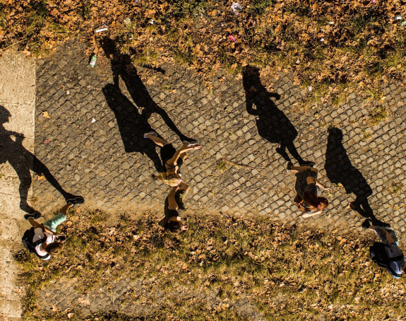 Foto: fünf laufende Menschen von oben mit langen Schatten