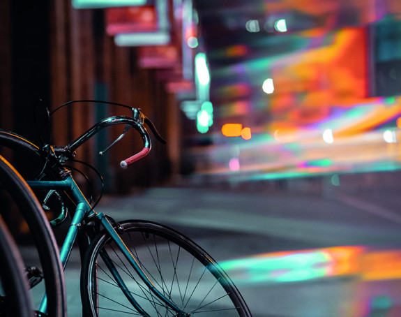 Foto: Stadtszene bei Nacht, Fahrrad im Vordergrund