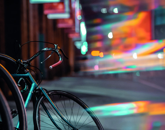 Foto: Stadtszene bei Nacht, Fahrrad im Vordergrund 