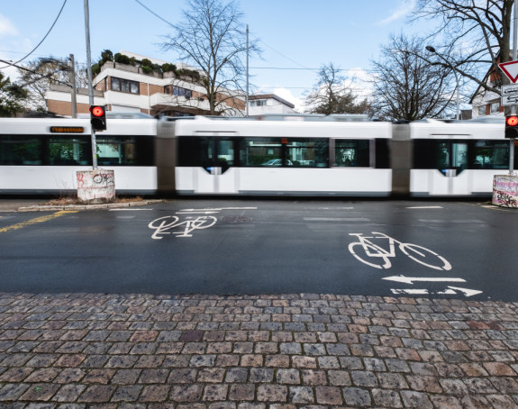 Fahrradstraße im Vordergrund, Tram in Bewegung im Hintergrund