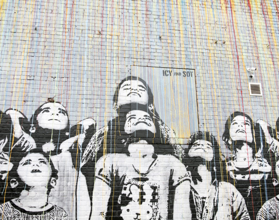 Schwarz-weißes Graffiti zeigt eine Gruppe nach oben schauender Kinder