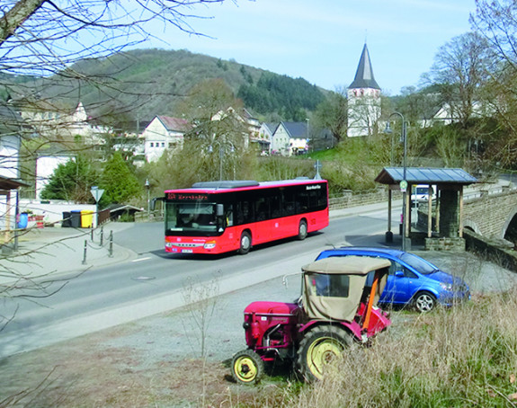 Bus fährt auf einer Landstraße in ländlicher Gegend 