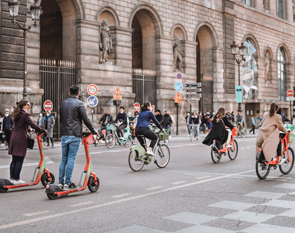 Menschen auf Scooter fahren auf Straße durch Paris