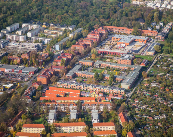 Luftbild einer Stadt mit Häuser, Grün, Parkplätzen