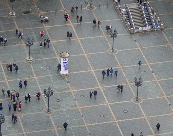 Blick von oben auf einen großen Stadtplatz auf dem Menschen umherlaufen