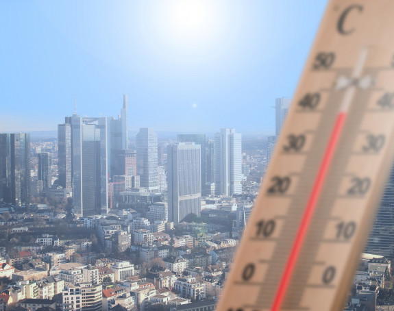 Foto: Thermometer zeigt Tempertaur von über 35 Grad an. Im Hintergrund eine Stadt