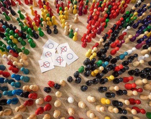 Bunte Spielfiguren mit angekreuzten Wahlzetteln in der Mitte. 