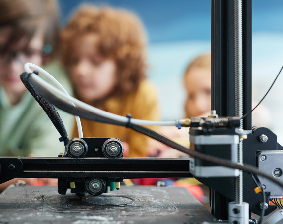 Kinder testen einen 3D-Drucker