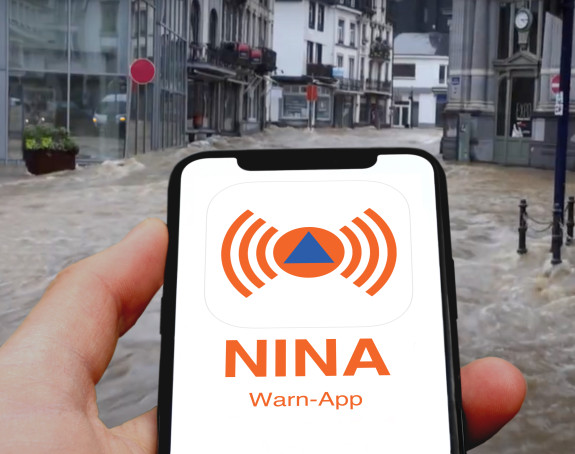 Überschwemmung in der Innenstadt, Warn-App auf dem Handy Überschwemmung in der Innenstadt, Warn-App Katwarn wird auf dem Handydisplay angezeigt