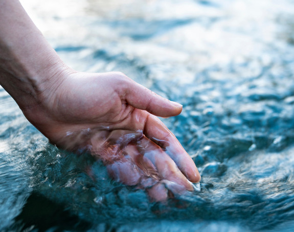 Hand berührt Wasser