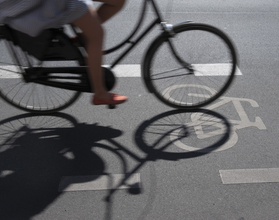 Foto: Radfahrerin und ihr Schatten auf dem Asphalt