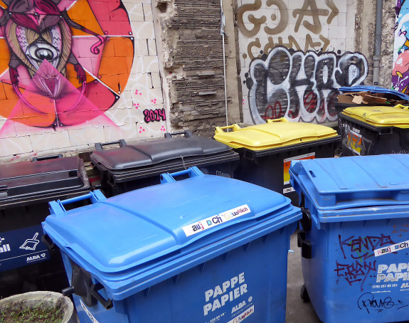 Foto: große Papier- und andere Recycling-Tonnen in einem Innenhof
