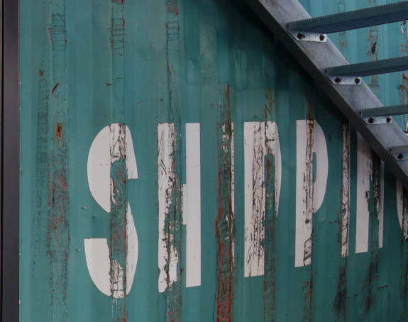 Foto: türkisfarbener Transport-Container mit der Aufschrift "Shipping"