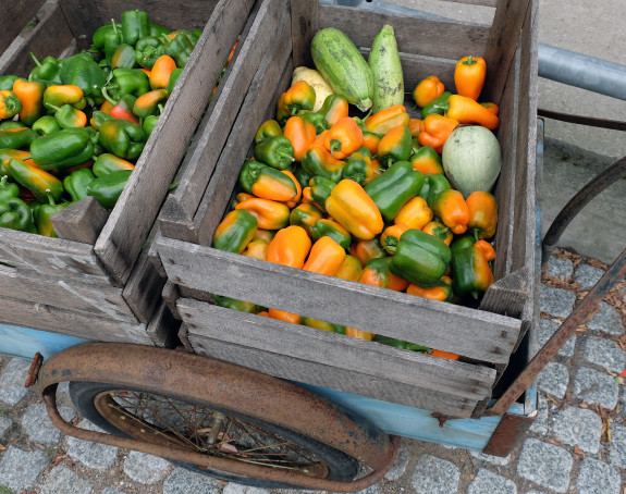 Foto eines Handwagens, der mit 2 Kisten voller Paprika