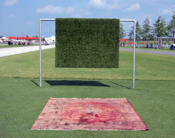 Foto einer Teppichstange mit einem darüber gehängetm Stück Kunstrasen