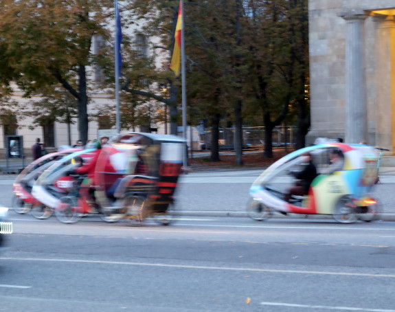 Foto zweier hintereinander fahrenden Fahrradrikschas