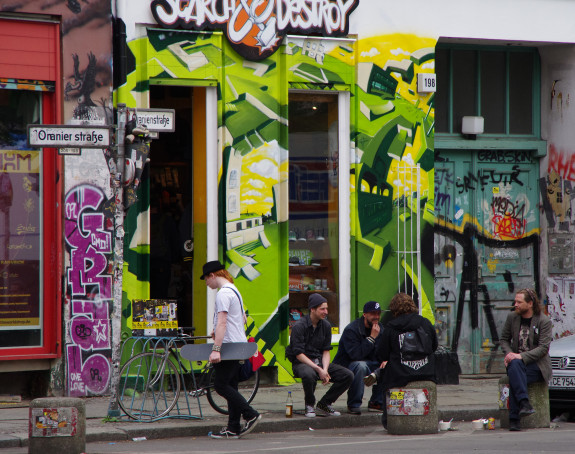 Foto: Straßenszene in Berlin-Kreuzberg, junge Männder sitzen im Straßenraum