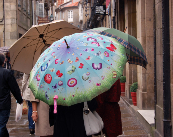 Foto: 3 Menschen unter Regenschirmen