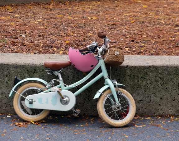 Foto: Kinderfahrrad mit rosafarbenem Helm am Lenker