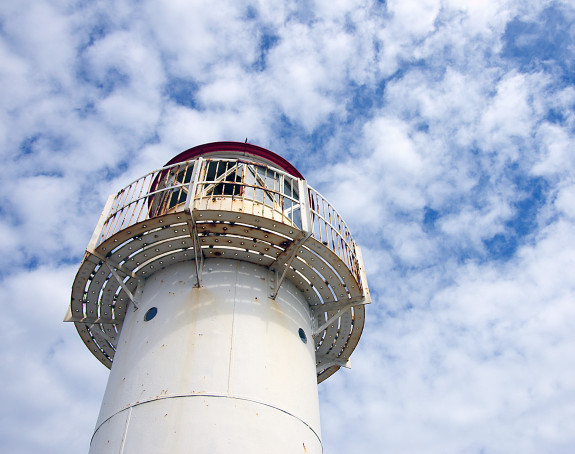 Foto eines Leuchtturms vor blauem Himmel