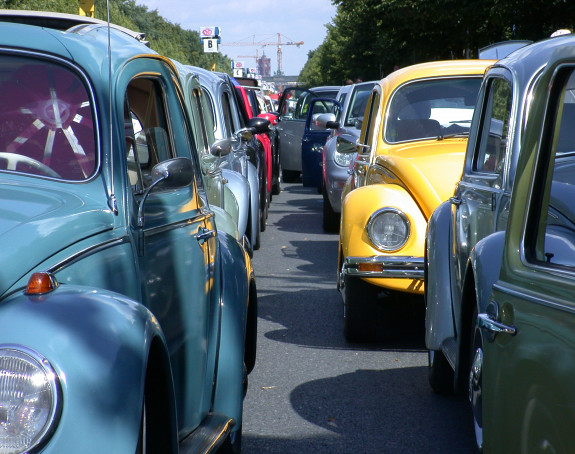 Foto: eine Straße ist zweispurig dicht mit VW-Käfer-Oldtimern beparkt