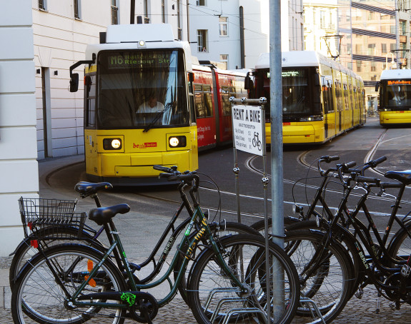 Foto: Leihfahrräder im Vordergrund, Straßenbahn im Hintergrund